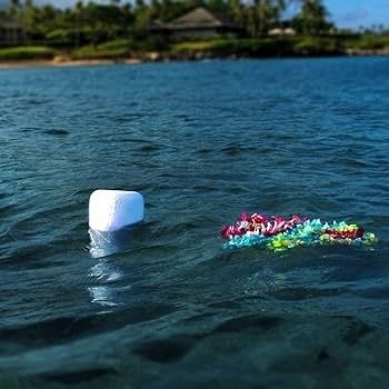 Witte drijvende urn en kleurrijk bloemenstuk op open water